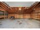 Spacious garage with wooden framing, overhead lighting, and ample storage space for tools and equipment at 8092 Ponderosa Ln, Parker, CO 80138