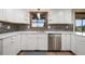 Bright kitchen features white cabinetry, stainless steel dishwasher, and a window overlooking the outdoors at 8092 Ponderosa Ln, Parker, CO 80138