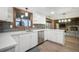 This bright kitchen boasts white cabinets, light countertops, and an adjacent living space with fireplace at 8092 Ponderosa Ln, Parker, CO 80138
