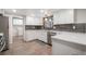 The bright kitchen features white cabinetry, stainless steel dishwasher, and a gray backsplash at 8092 Ponderosa Ln, Parker, CO 80138