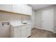 Laundry room featuring white cabinets, light countertop, sink, and two entry doors at 8092 Ponderosa Ln, Parker, CO 80138