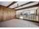 Open living room with wood paneling, exposed ceiling beams, and neutral carpet at 8092 Ponderosa Ln, Parker, CO 80138