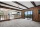 The spacious living room offers wood paneling, exposed beams, access to the kitchen and an enclosed porch at 8092 Ponderosa Ln, Parker, CO 80138
