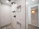 Modern shower with vertically laid tile and black fixtures and built-in shelving at 8092 Ponderosa Ln, Parker, CO 80138