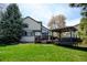 Sprawling backyard featuring a well-maintained lawn, mature trees, and a charming pergola-covered deck, perfect for outdoor living at 879 E 133Rd Ave, Thornton, CO 80241