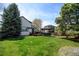 Expansive backyard with lush green grass, a wooden deck, and mature trees, creating a serene outdoor oasis at 879 E 133Rd Ave, Thornton, CO 80241