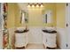 Yellow bathroom featuring dual vessel sinks, classic white cabinets, and decorative mirrors at 879 E 133Rd Ave, Thornton, CO 80241