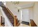 Inviting foyer with wood staircase, hardwood floors, and front door at 879 E 133Rd Ave, Thornton, CO 80241