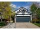 Home featuring a large garage, well-maintained lawn, and attractive exterior details at 879 E 133Rd Ave, Thornton, CO 80241