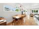 Dining area with hardwood floors, a wooden table, and modern decor leads to a sunlit living room at 4129 Zenobia St, Denver, CO 80212
