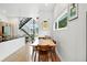 Bright dining area features a stylish table and chairs with modern decor, adjacent to a staircase and a window view at 4129 Zenobia St, Denver, CO 80212