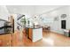 Open-concept kitchen featuring an island, modern appliances, and hardwood floors at 4129 Zenobia St, Denver, CO 80212