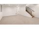 Spacious, carpeted basement area with staircase and white walls, perfect for entertaining at 4303 Osceola St, Denver, CO 80212