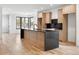 Modern kitchen featuring an island, sleek countertops, and light wood cabinets at 4303 Osceola St, Denver, CO 80212