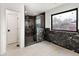 Featuring a luxurious shower, this bathroom is tiled with striking dark marble-like tile at 4303 Osceola St, Denver, CO 80212