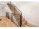 Staircase features light wood stairs with dark metal railing and light hardwood floors at 4303 Osceola St, Denver, CO 80212