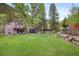 Expansive backyard with a well-manicured lawn, mature trees, and a serene river flowing along the property line at 715 Main St, Georgetown, CO 80444