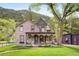 Charming two-story home with a covered porch and a well-manicured lawn against a mountain backdrop at 715 Main St, Georgetown, CO 80444