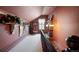 Upper hallway with pink walls, decor shelving, and a cozy sitting nook with window, offering a serene transition space at 715 Main St, Georgetown, CO 80444