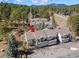 An aerial view of the townhouse complex surrounded by many trees and scenic mountain views in the distance at 28110 Meadow Dr, Evergreen, CO 80439