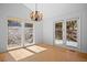 Bright dining area features a chandelier, hardwood floors, and French doors leading to outdoor deck at 28110 Meadow Dr, Evergreen, CO 80439
