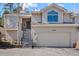 Inviting exterior of home with a two-car garage and staircase leading to the front door at 28110 Meadow Dr, Evergreen, CO 80439