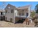 A view of the rear exterior highlighting the deck with a black railing, and the beige siding at 28110 Meadow Dr, Evergreen, CO 80439