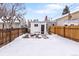 Cozy backyard with privacy fence, covered patio, and a snowy lawn, perfect for leisure and entertaining at 2647 N High St, Denver, CO 80205
