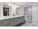 Modern bathroom with double sink vanity, stylish mirrors, elegant gold fixtures, and tiled walk-in shower at 2647 N High St, Denver, CO 80205