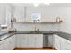 Modern kitchen featuring white cabinets, granite countertops, stainless steel appliances, and stylish backsplash at 2647 N High St, Denver, CO 80205