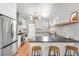 Well-lit kitchen with stainless steel appliances, white cabinets, quartz countertop, and wooden stools at 2647 N High St, Denver, CO 80205