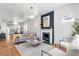 Bright living room features a cozy fireplace, hardwood floors, and an open floor plan to the kitchen at 2647 N High St, Denver, CO 80205