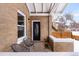 Cozy porch with seating area, showing brick exterior with elegant front door, and winter scenery at 2647 N High St, Denver, CO 80205