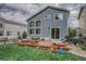 Backyard features a wooden deck, lush green lawn, beautiful blue siding, and mature trees that add a serene touch at 5934 S Yampa St, Aurora, CO 80016