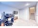 Basement featuring a staircase, sim racing equipment, and carpeted floors at 5934 S Yampa St, Aurora, CO 80016