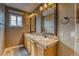 Bathroom featuring a double sink vanity with warm wood cabinets and framed mirrors at 5934 S Yampa St, Aurora, CO 80016
