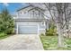 Charming two-story home with a well-manicured lawn and a gray two car garage door at 5934 S Yampa St, Aurora, CO 80016