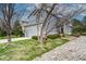 Inviting gray two-story home with a manicured lawn, stone walkway, and delightful landscaping at 5934 S Yampa St, Aurora, CO 80016