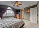 Comfortable main bedroom featuring a ceiling fan, large window, and neutral decor at 5934 S Yampa St, Aurora, CO 80016