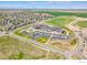 Expansive aerial view of a modern school building with a large parking lot and sports fields, surrounded by a residential neighborhood at 2122 Opal Ave, Brighton, CO 80603