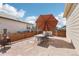 Enjoy outdoor living on this stone patio with umbrella, fire pit, and string lights for backyard enjoyment at 2122 Opal Ave, Brighton, CO 80603