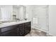 This bathroom features double sinks, framed mirrors, a glass-enclosed shower, and decorative tile floors at 2122 Opal Ave, Brighton, CO 80603