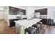 Modern kitchen features dark cabinets, stainless steel appliances, and a large island with seating at 2122 Opal Ave, Brighton, CO 80603