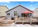 Backyard view of the house with a wooden deck, outdoor seating, and a large red umbrella at 1668 Rosemary Dr, Castle Rock, CO 80109