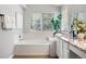 Bright bathroom featuring a tub and vanity with granite counters and a window at 1668 Rosemary Dr, Castle Rock, CO 80109