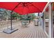 Outdoor wooden deck with a red umbrella, table and chairs, and a grill, perfect for entertaining at 1668 Rosemary Dr, Castle Rock, CO 80109