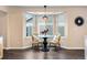 Cozy dining area featuring a round glass table, wicker chairs, and a bay window providing natural light at 1668 Rosemary Dr, Castle Rock, CO 80109