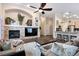 Open-concept living room with a stone fireplace, modern ceiling fan, and seamlessly connects to the kitchen at 1668 Rosemary Dr, Castle Rock, CO 80109