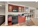 Stylish basement bar features custom cabinets, mini-fridge, and bar stools for entertaining at 24965 E Roxbury Pl, Aurora, CO 80016
