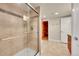 Bathroom featuring a modern shower with glass door, bright tile, and a sauna beyond the open door at 24965 E Roxbury Pl, Aurora, CO 80016